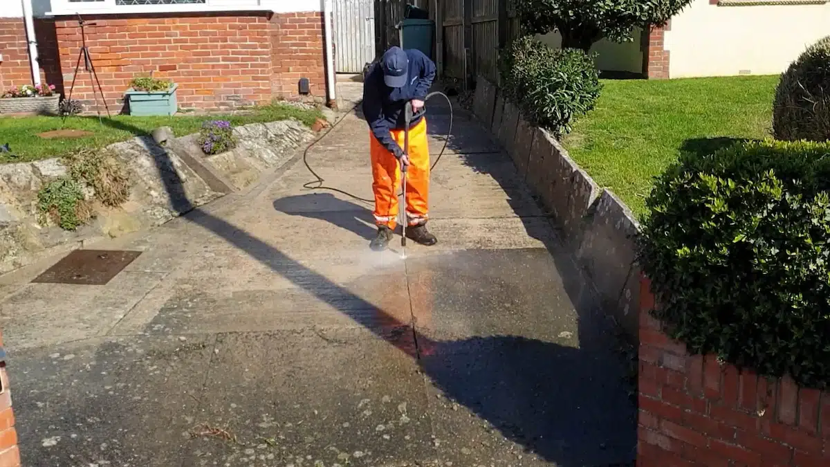 Driveway being pressure washed, half cleaned and half still to go